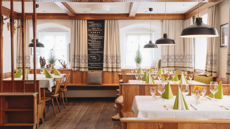 Wunderschön erhaltene alte Stube, © Niederösterreich Werbung/Julius Hirtzberger Gemütliche, traditionelle Gaststube mit Holzmöbeln, gedeckten Tischen und grünen Servietten.