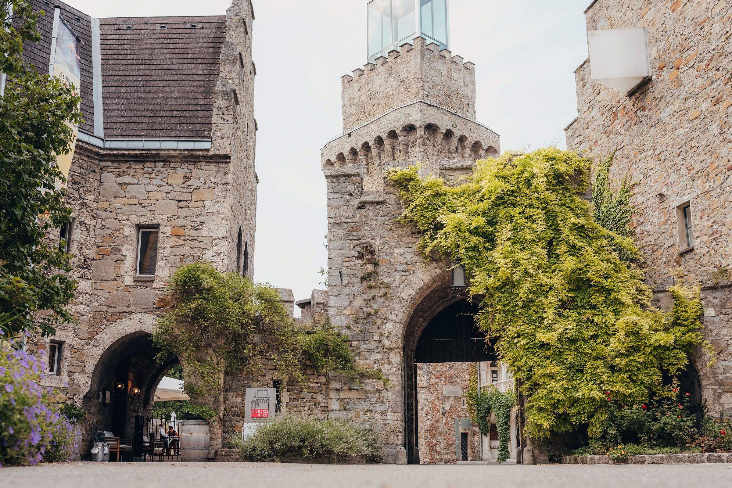Entrance gate of Schloss Rothschild with overgrown stone walls.