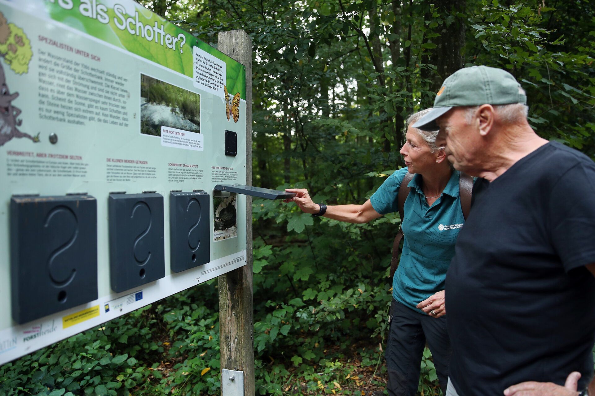 Mann und Frau betrachten eine Tafel im Naturpark Ybbstal im Mostviertel.