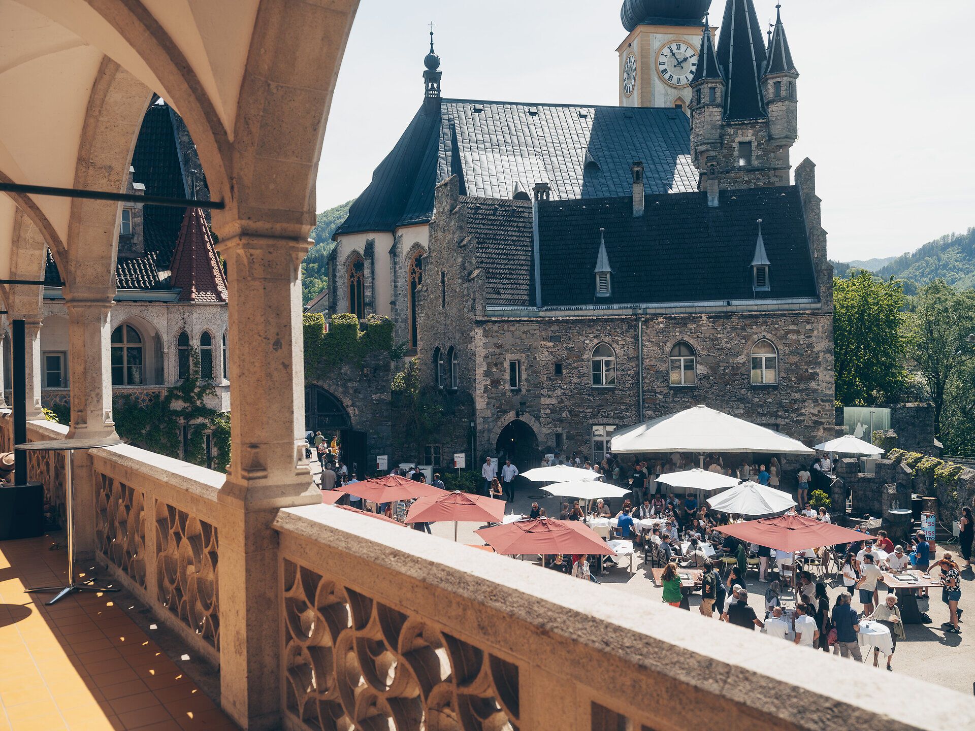 Inmitten der malerischen Kulisse des Schlosses Rothschild versammeln sich Menschen, um die Köstlichkeiten des Street Foods zu genießen. Die bunten Markisen und die lebhafte Atmosphäre laden dazu ein, die Vielfalt der regionalen Spezialitäten zu entdecken und die warmen Sonnenstrahlen zu genießen.
