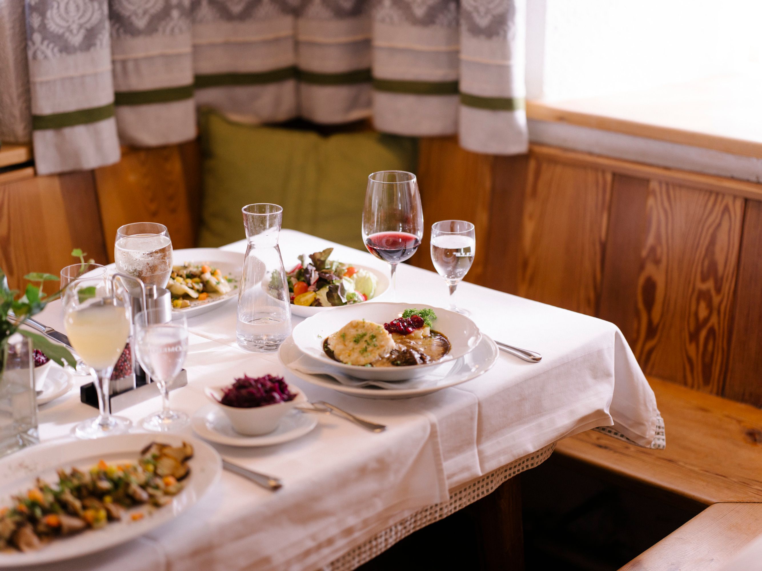 Ein gedeckter Tisch mit verschiedenen Gerichten und Getränken in einem gemütlichen Restaurant.
