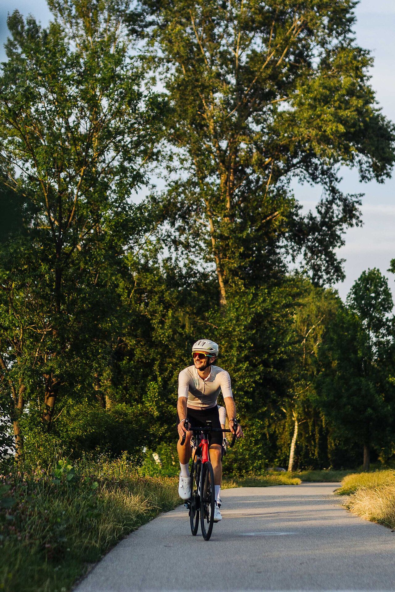 Ein Rennradfahrer auf seinem Bike fährt auf einem schmalen Weg.