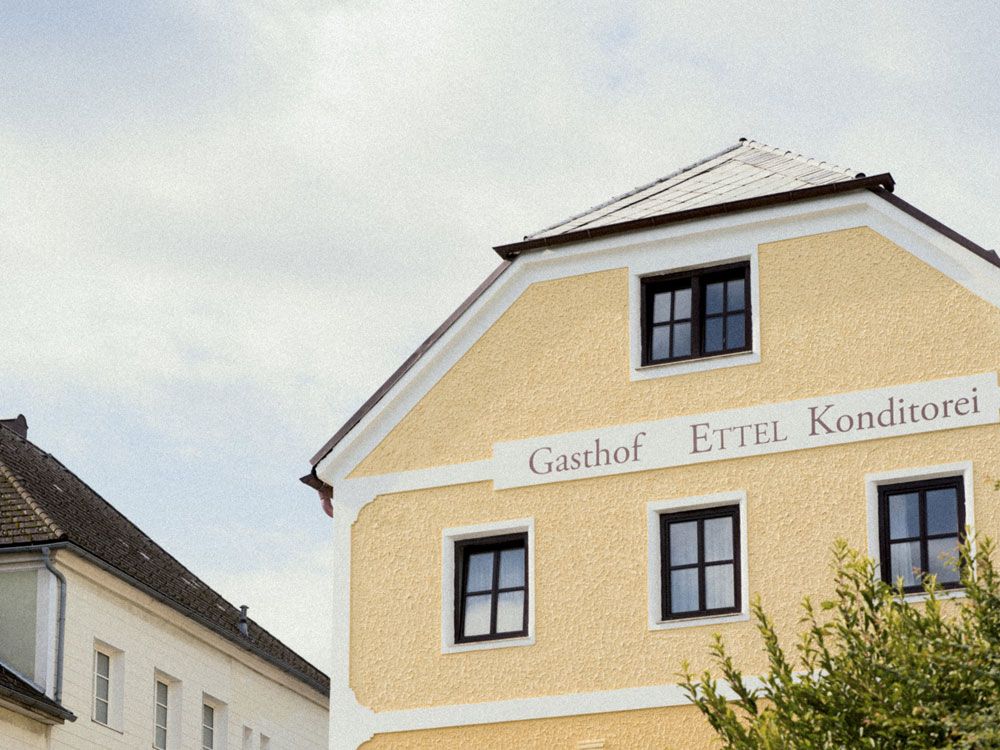 Gelbes Gebäude mit der Aufschrift 'Gasthof Ettel Konditorei'.