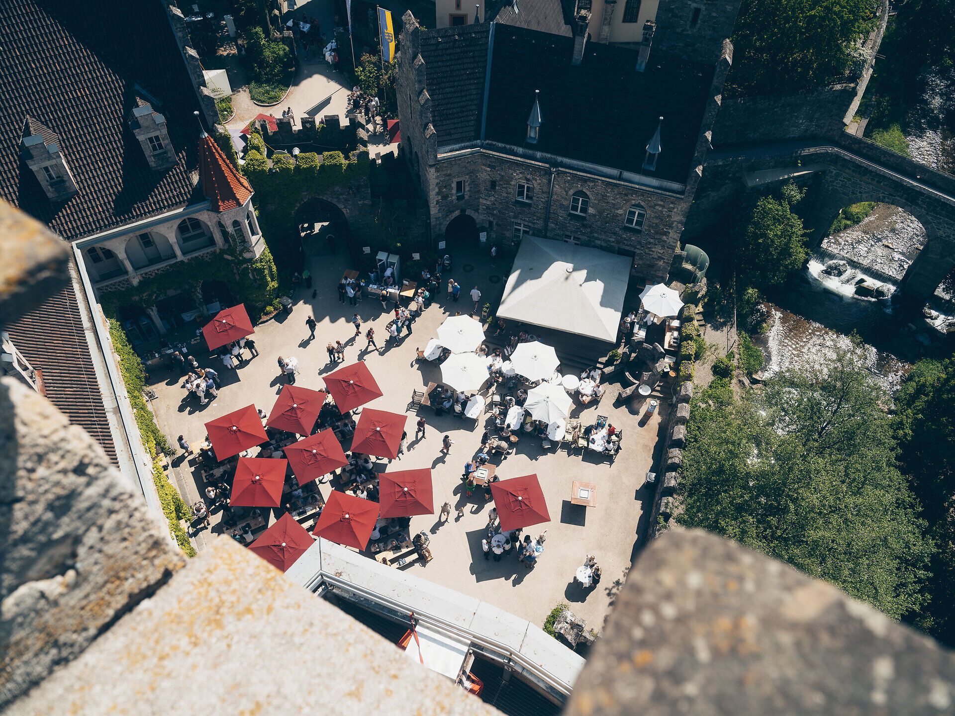 Unter den schattenspendenden roten Sonnenschirmen versammeln sich Genießer, um die kulinarischen Köstlichkeiten des Street Foods zu erleben. Die lebhafte Atmosphäre und der Duft von frisch zubereiteten Speisen laden dazu ein, die Vielfalt der regionalen Spezialitäten zu entdecken. Ein perfekter Ort, um die Seele baumeln zu lassen und die Schönheit der Umgebung zu genießen.
