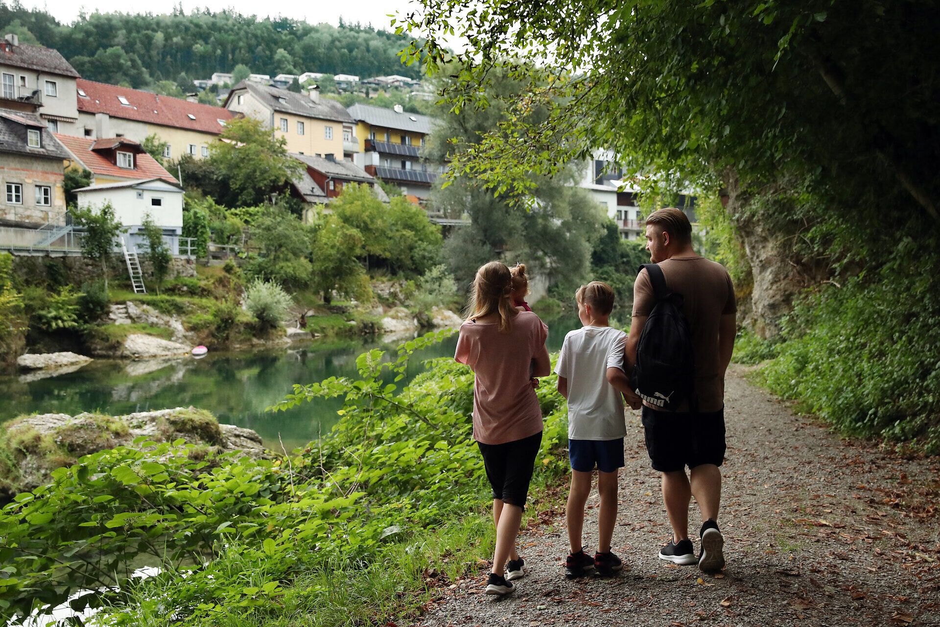 Familie spaziert entlang einem Fluss im Naturpark Ybbstal bei Waidhofen an der Ybbs im Mostviertel.